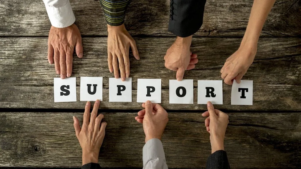 People holding letters spelling support